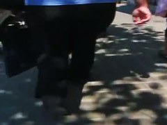 A hefty xxxl woman in a street candid video walks in tight black jeans