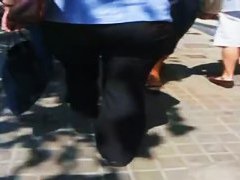 A hefty xxxl woman in a street candid video walks in tight black jeans