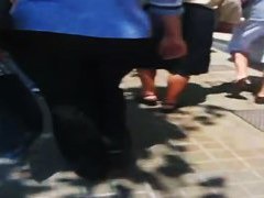 A hefty xxxl woman in a street candid video walks in tight black jeans