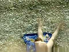 Nudist couple making 69 in the rocky beach