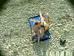 Nudist couple making 69 in the rocky beach