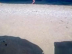 Pregnant nudist woman at beach