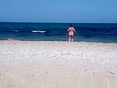 Pregnant nudist woman at beach