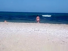 Pregnant nudist woman at beach