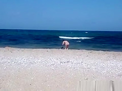 Pregnant nudist woman at beach
