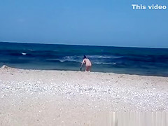 Pregnant nudist woman at beach