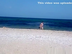 Pregnant nudist woman at beach