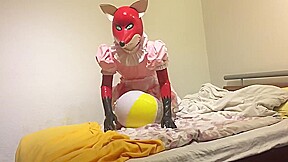 Rubber fox maid plays with beach ball